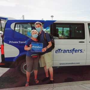 Viajeros en la salida de llegadas del aeropuerto de Cancún con su chofer de eTransfers