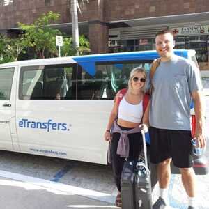 Viajeros en la salida de llegadas del aeropuerto de Cancún con su chofer de eTransfers