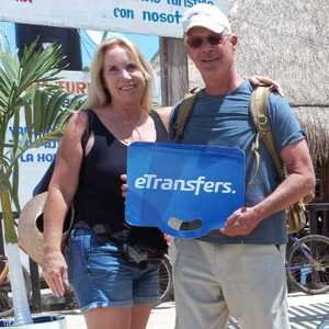 Viajeros en la salida de llegadas del aeropuerto de Cancún con su chofer de eTransfers