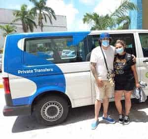 Viajeros en la salida de llegadas del aeropuerto de Cancún con su chofer de eTransfers